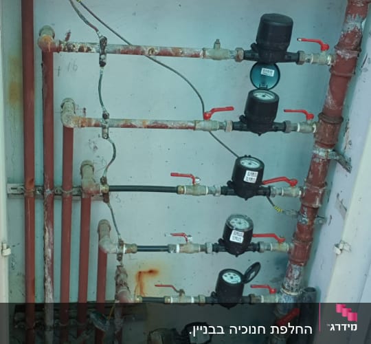 צינורות מים עם ברזים ומדי מים בארון פתוח